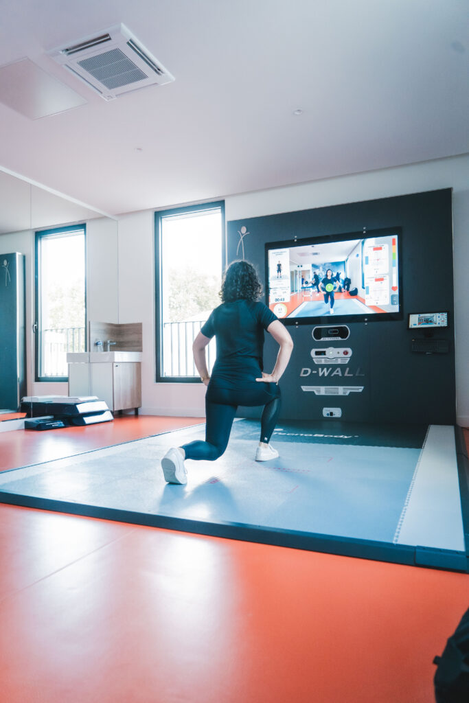 Une femme fait un exercice avec un DWall